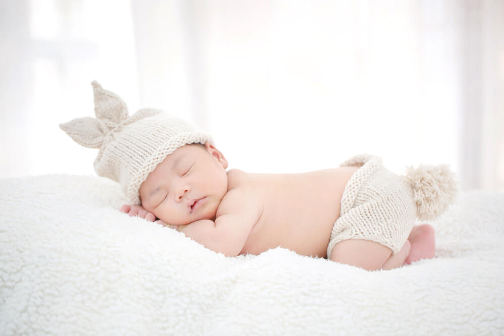 baby sleeping on bed